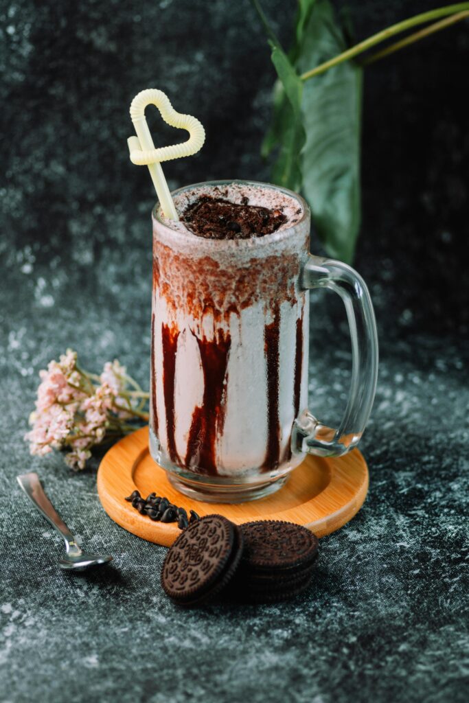 Indulge in a chocolate milkshake topped with crumbled cookies and adorned with a heart-shaped straw.