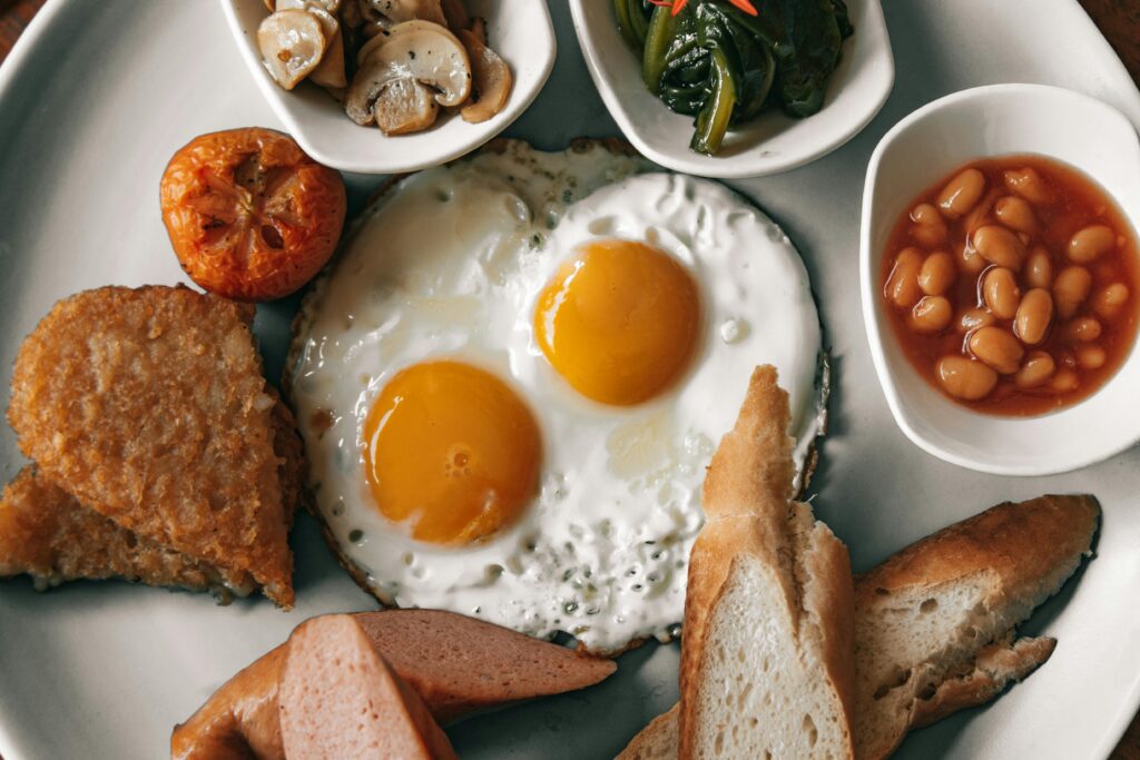 Delicious full English breakfast with fried eggs, toast, and baked beans on a plate.