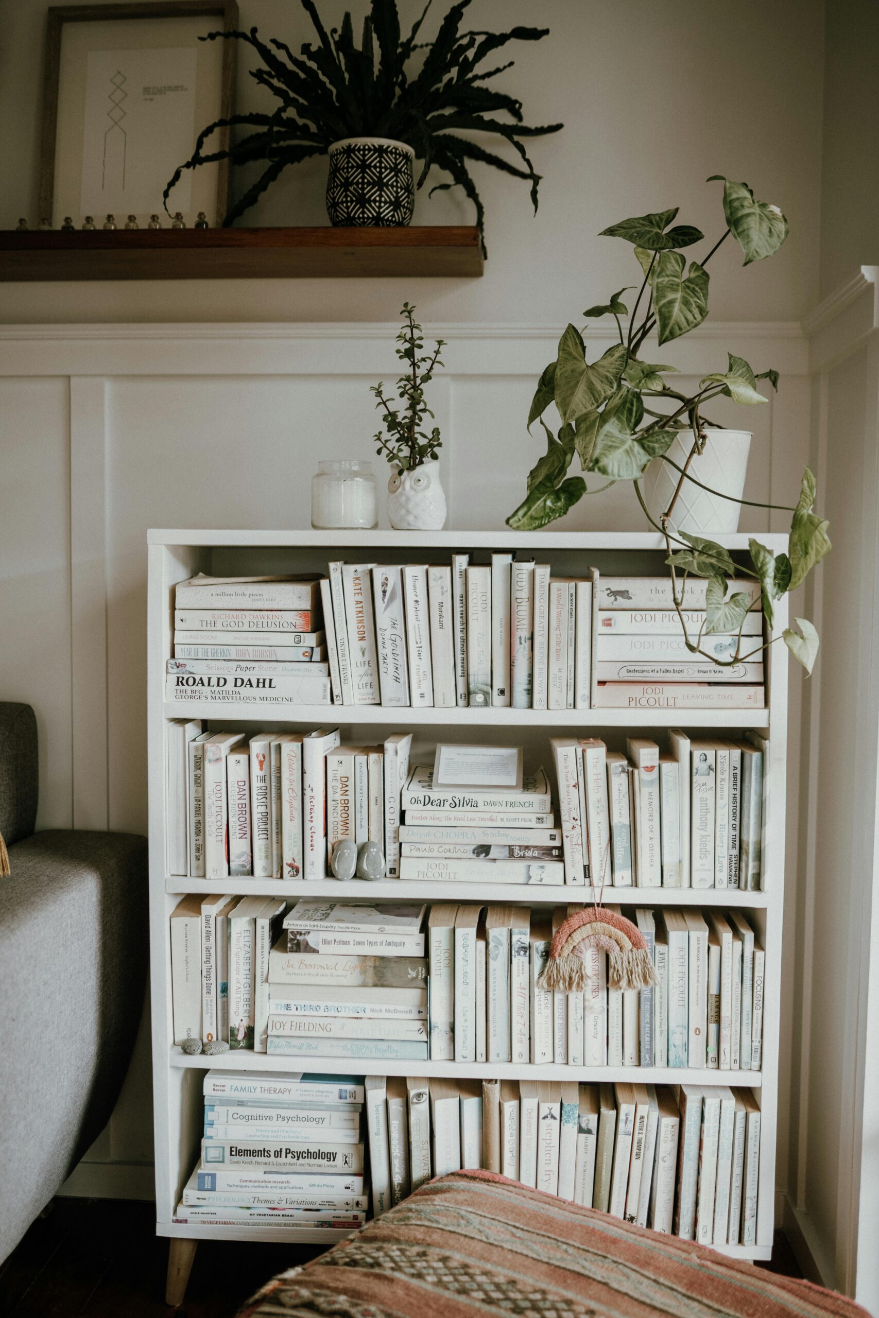 Minimalist home interior with a stylish bookshelf, showcasing Scandinavian design and greenery.