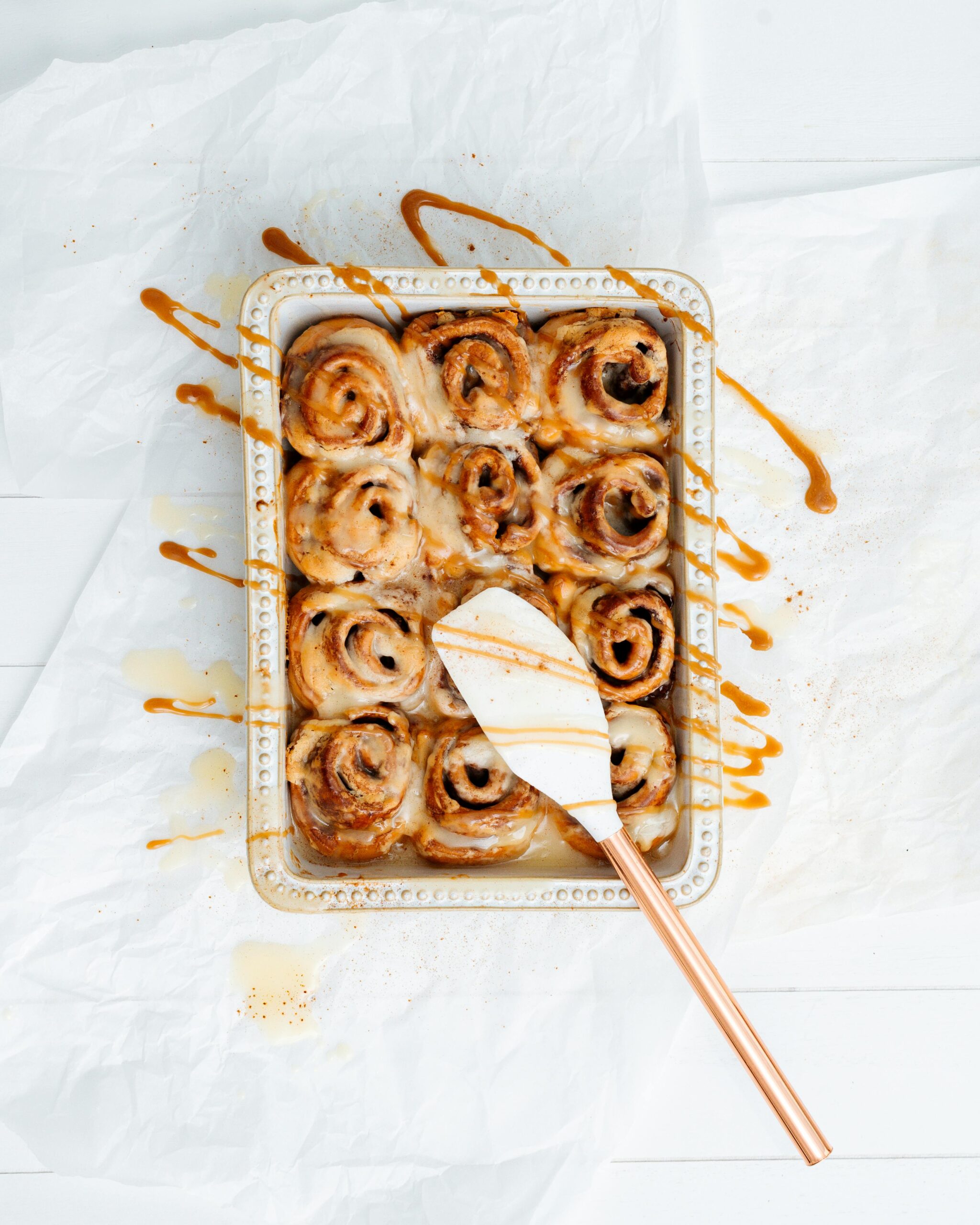 Top view of delicious homemade cinnamon rolls with icing on a baking tray.