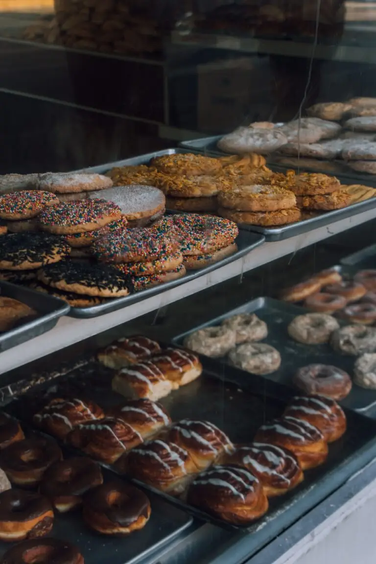 A delicious assortment of pastries and donuts showcased in a bakery window display.
