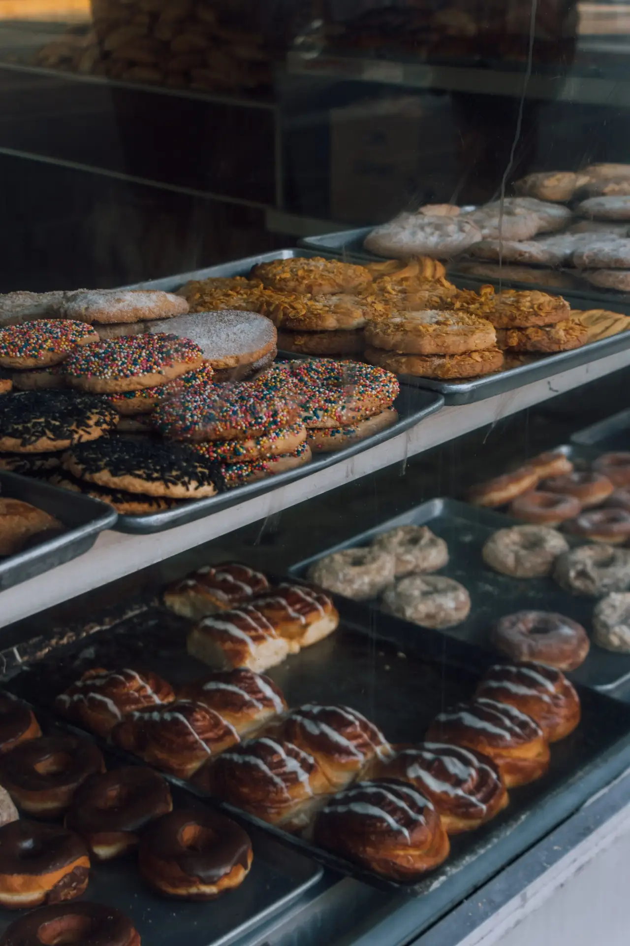 A delicious assortment of pastries and donuts showcased in a bakery window display.