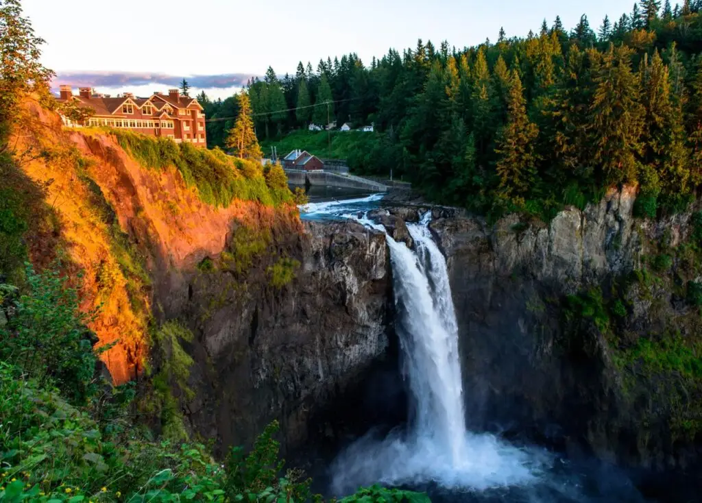 Breathtaking view of Snoqualmie Falls with vibrant sunset hues and lush greenery.