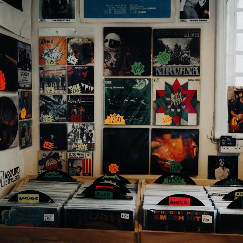 Retro vinyl records and albums lining the wooden shelves of a classic record store in Abergele, UK.