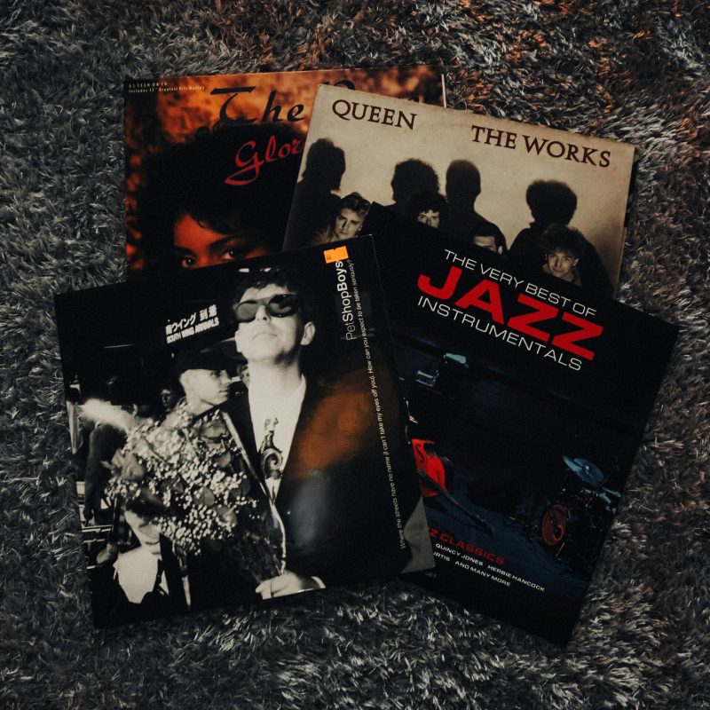 Collection of vintage vinyl records showcasing iconic albums on a plush textured rug.