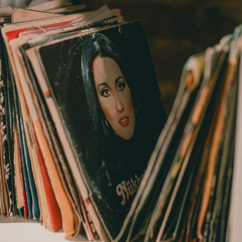 Collection of vintage vinyl records with various album covers neatly arranged on a white display shelf.